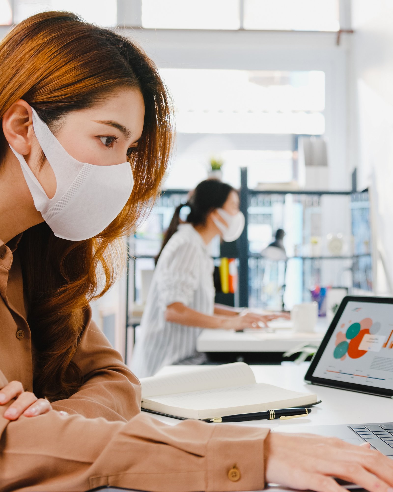 asia-businesswoman-entrepreneur-wearing-medical-face-mask-social-distancing-new-normal-situation-virus-prevention-while-using-laptop-back-work-office